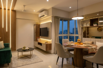 Modern open small living dining room design in a Kolkata flat with wood paneling, TV unit, round dining table, and built-in wall bench.